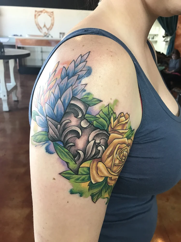 Color flower and filigree tattoo on the upper arm